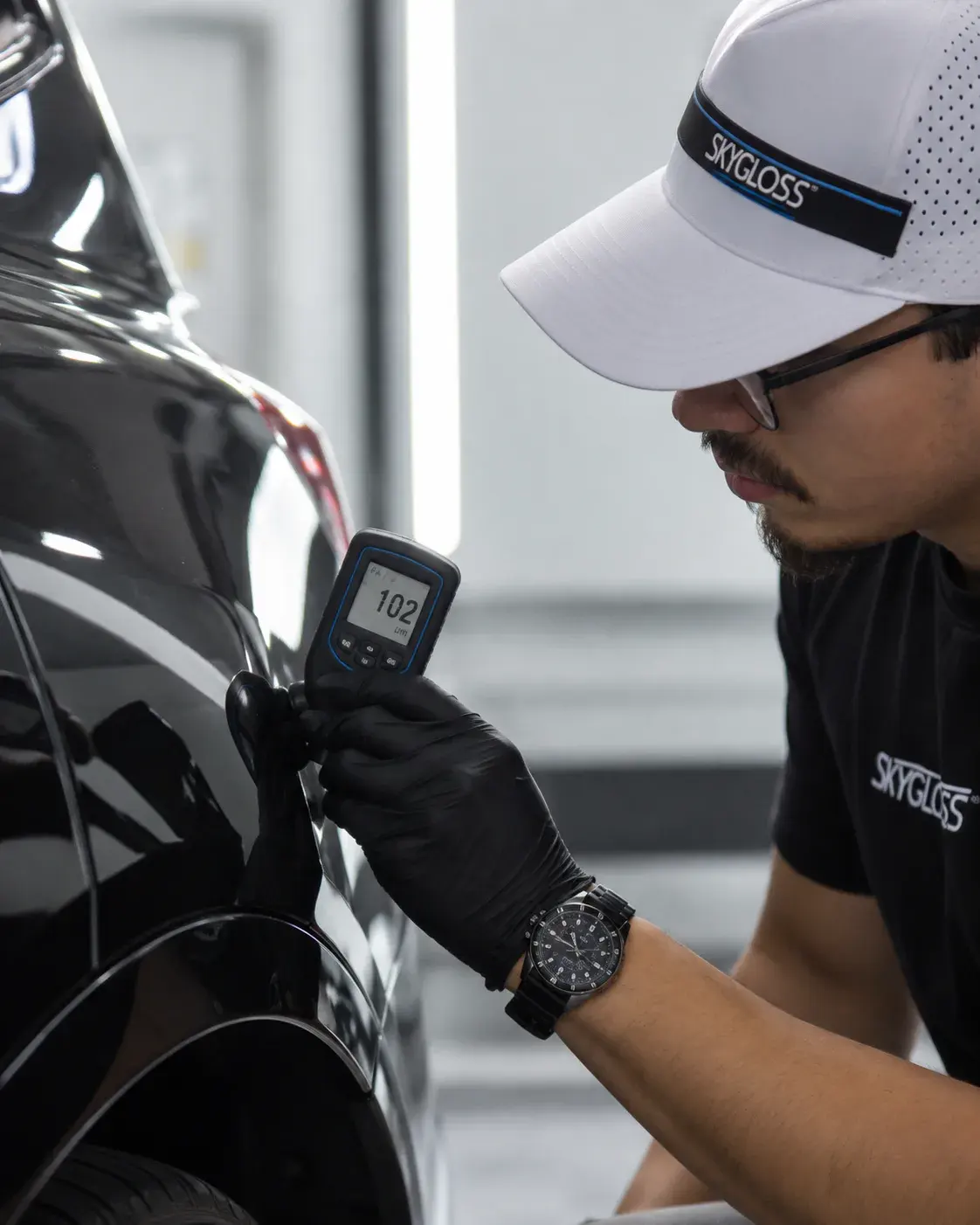 A SkyGloss technician checking the condition of a vehicle panel