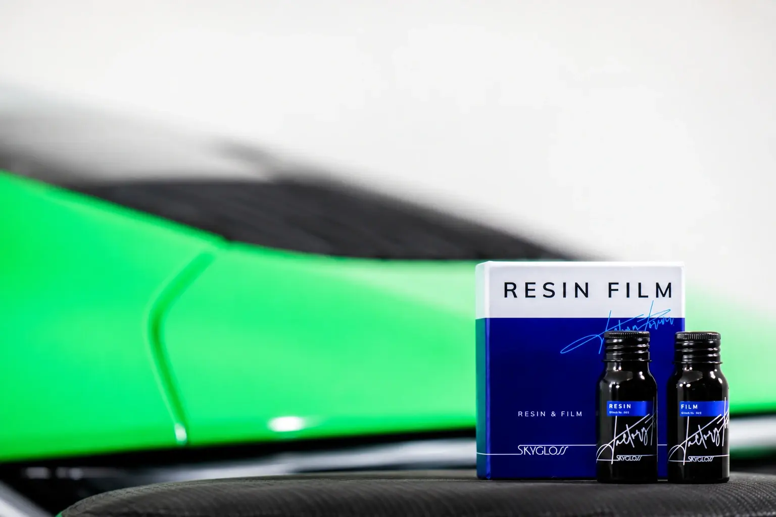 RESIN FILM bottles and packaging in front of a finished vehicle
