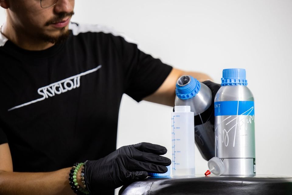 A technician pouring from a SkyGloss bottle