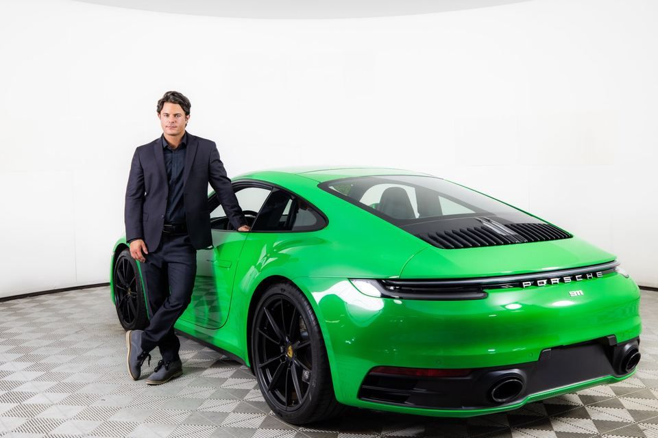 Standing beside a finished green Porsche 911